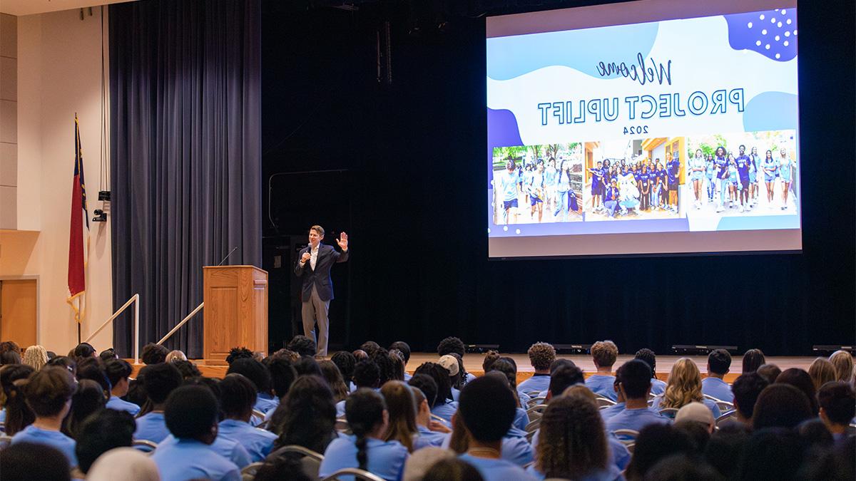 一个人，李校长. 罗伯茨, standing on stage in an auditorium and speaking to high schoolers attending a summer enrichment camp called Project Uplift at UNC-Chapel Hill.